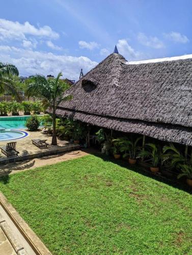 a large building with a yard and a swimming pool at Nightingale Apartments Hotel Mombasa in Shanzu
