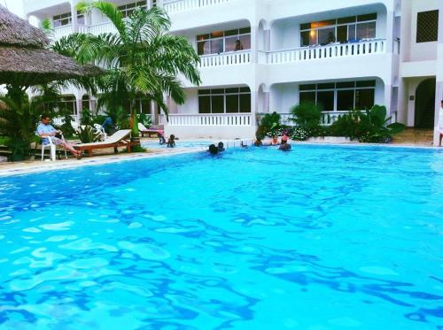 a large swimming pool in front of a building at Nightingale Apartments Hotel Mombasa in Shanzu