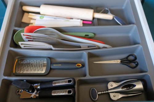 a drawer filled with utensils and scissors and sidx sidx sidx at Four Sisters Luxury Rooms in Siauliai in Šiauliai