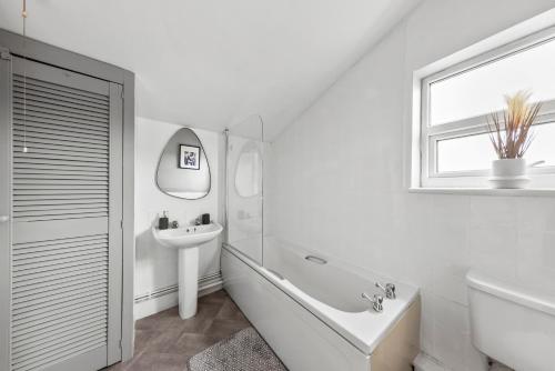 a white bathroom with a tub and a sink at Stylish Appt in Medway ideal for NHS and contractors, free parking in Gillingham
