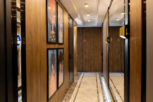 a hallway with wood paneling and paintings on the walls at Four Sisters Luxury Rooms in Siauliai in Šiauliai