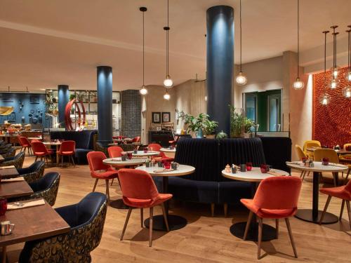 un comedor con mesas y sillas y un restaurante en Sofitel Brussels Europe, en Bruselas