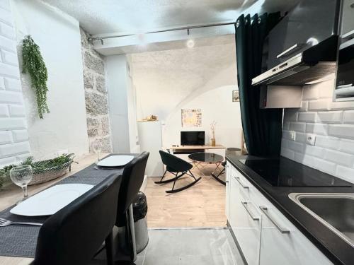 une cuisine avec une table et des chaises dans une pièce dans l'établissement Studio Vieil Antibes rue du Bateau, à Antibes