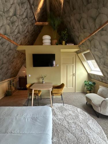 uma sala de estar com uma mesa e uma televisão em Bed bij Bistro em Medemblik