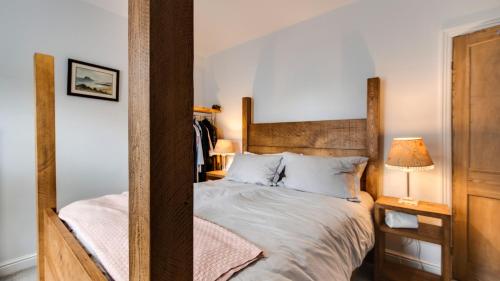 a bedroom with a bed with a wooden headboard at Ryecroft Cottage - Matlock in Two Dales