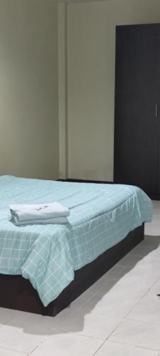 a bed with a blue comforter on top of it at Leisure Residence in Pattaya