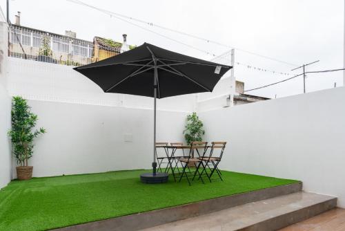 a patio with a table and chairs and an umbrella at Host Wise - Central Duplex House - Terrace in Vila Nova de Gaia
