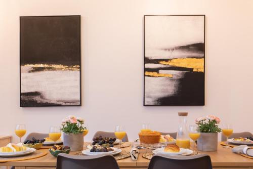 a dining room table with food and orange juice at Host Wise - Central Duplex House - Terrace in Vila Nova de Gaia