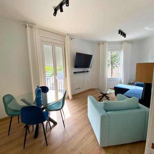 a living room with a table and a blue couch at Amazing Apartment in Poblenou with 3 bedrooms in Barcelona