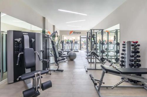 a gym with a lot of treadmills and weights at Barceló Corralejo Bay - Adults Only in Corralejo
