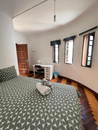 a bedroom with a bed in a room with windows at Asprela Guest House in Porto