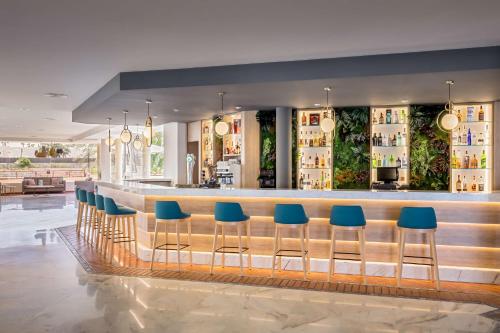 a bar with blue stools in a restaurant at Barceló Corralejo Bay - Adults Only in Corralejo