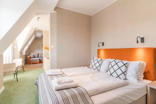 a bedroom with a bed with white pillows on it at Villa Verdi Pleasure & Spa in Łeba