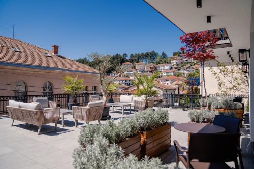 a patio with tables and chairs on a balcony at Villa & Spa Chunarot in Ohrid