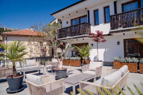 a patio with chairs and tables in front of a building at Villa & Spa Chunarot in Ohrid