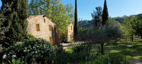 una vieja casa de piedra en medio de un jardín en Chambres d'Hôtes Aux Tournesols, en Malaucène