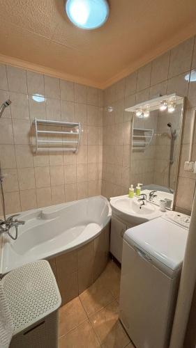 a bathroom with a tub and a sink at Kiss Vendégház 1. in Kaposvár