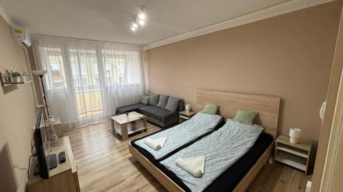 niewielka sypialnia z łóżkiem i kanapą w obiekcie Kiss Vendégház 1. w mieście Kaposvár