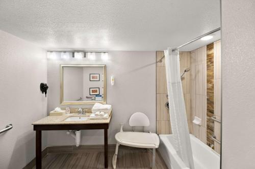 a bathroom with a sink and a tub and a toilet at Comfort Inn & Suites in Lovington