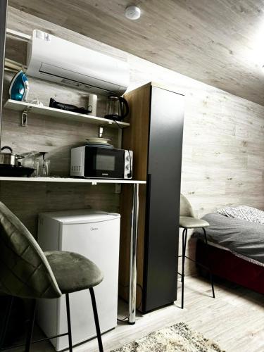 Zimmer mit einem Bett und einer Küche mit einem Kühlschrank. in der Unterkunft Мини отель in Chişinău