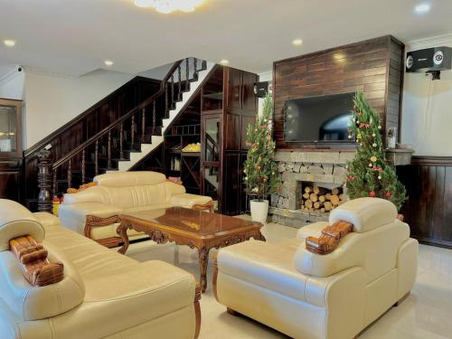 a living room with white furniture and a fireplace at Villa Đà Lạt View Thông in Khu Chi Lăng