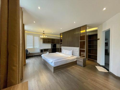 a bedroom with a large white bed and wooden floors at Villa Đà Lạt View Thông in Khu Chi Lăng