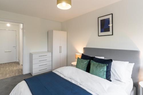 a bedroom with a bed with blue and white pillows at Host & Stay - 36 Waterside Place in Taunton
