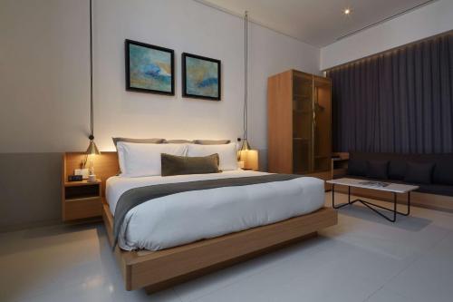 a bedroom with a large bed and a couch at Umbral, Curio Collection By Hilton in Mexico City
