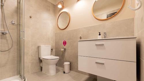 a bathroom with a toilet and a shower and a mirror at VacationClub - Apartamenty Zakopiańskie Apartament 112 in Zakopane