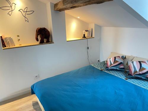 une chambre avec un lit bleu et un éléphant en peluche sur le mur dans l'établissement Victor Hugo - Calme, à Auch