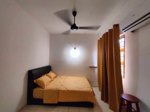 - une chambre avec un lit et un ventilateur de plafond dans l'établissement Rawang HoBudjet Homestay, à Rawang
