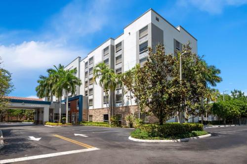 un edificio bianco con palme in un parcheggio di Hampton Inn Weston Fort Lauderdale a Weston