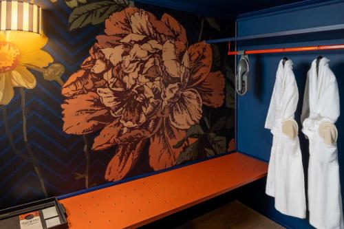 a bathroom with a flower painting on the wall at Anglo American Hotel Florence, Curio Collection By Hilton in Florence