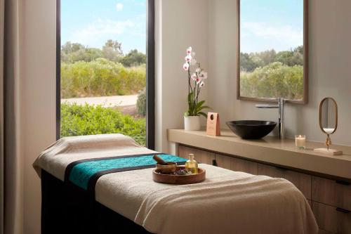 Tivoli Alvor Algarve - All Inclusive Resort في ألفور: حمام فيه سرير ومغسلة ونافذة