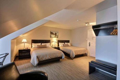 ロベルバルにあるTravelodge by Wyndham Robervalのベッド2台とソファが備わるホテルルームです。
