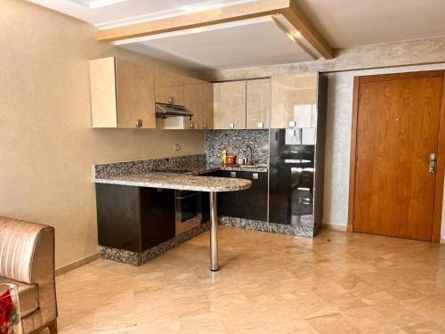 uma cozinha com uma mesa e um frigorífico preto em Studio Cosy Centre Ville Casablanca em Casablanca