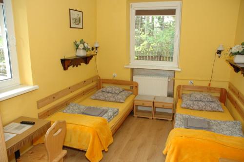 two beds in a room with yellow walls at ORION in Karpacz
