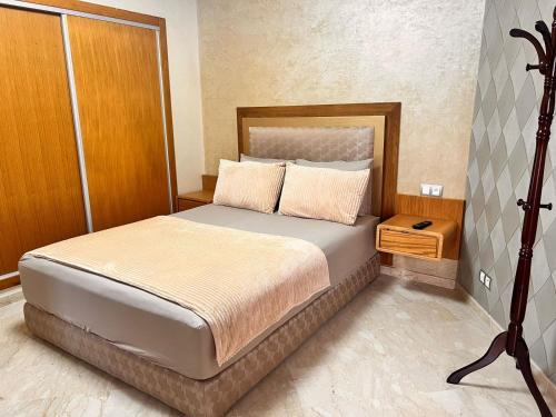 um quarto com uma cama grande e uma cabeceira em madeira em Studio Cosy Centre Ville Casablanca em Casablanca