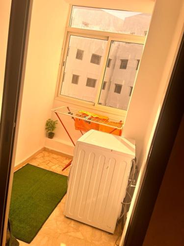 um pequeno quarto com um tapete verde e uma janela em Studio Cosy Centre Ville Casablanca em Casablanca