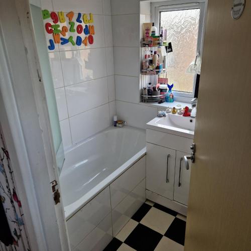 uma casa de banho com uma banheira e um lavatório em Guest house with appliances em Brixworth