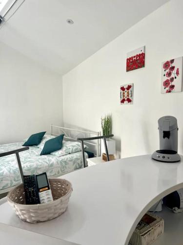 Habitación con encimera blanca, mesa y cama en Casa 4 Saisons - Studio - Piscine et Jardin - Brive, en Brive-la-Gaillarde