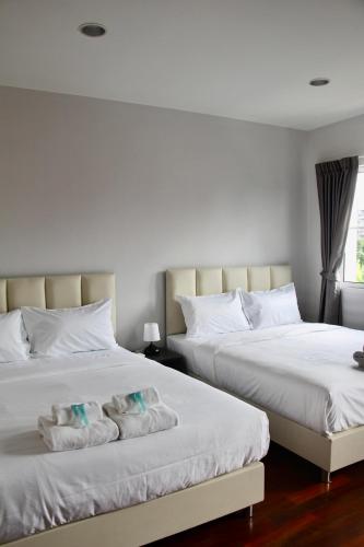 two beds sitting next to each other in a bedroom at Entire 3BR Townhome, Pool, Sukhumvit, BTS&MRT Asok in Bangkok