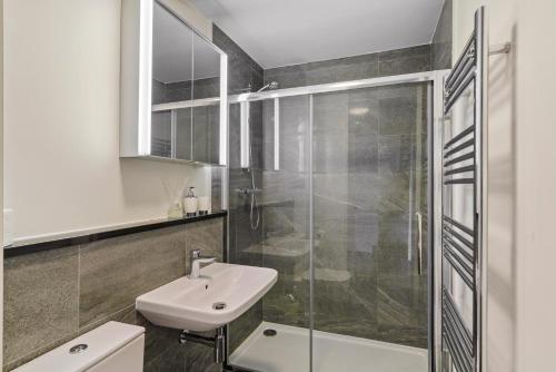 a bathroom with a white sink and a shower at Boutique and Stylish Wakefield Apartment in Wakefield