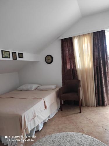 ein Hotelzimmer mit 2 Betten und einem Stuhl in der Unterkunft Apartman u sumi nedaleko od mora in Bigovo