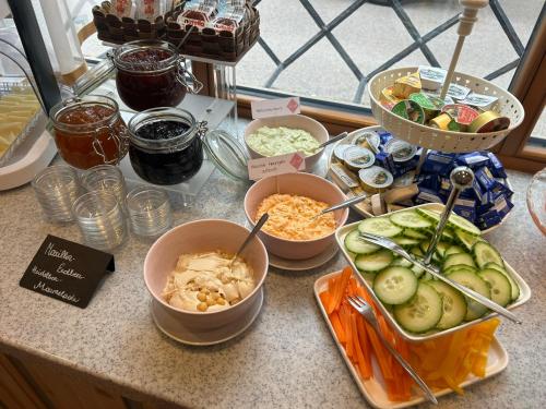 eine Theke mit Schüsseln mit Lebensmitteln auf einem Tisch in der Unterkunft Hotel zur Post in Gumpoldskirchen