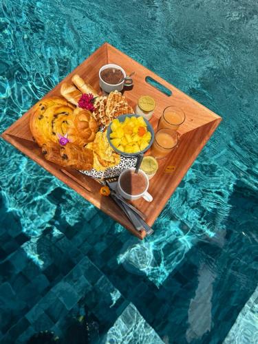 una bandeja de comida en una mesa junto a la piscina en Panorama180, en Le Marin