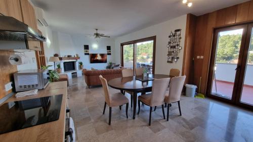 cocina y sala de estar con mesa y sillas en Seafront rural big house at Solta Croacia island, en Nečujam