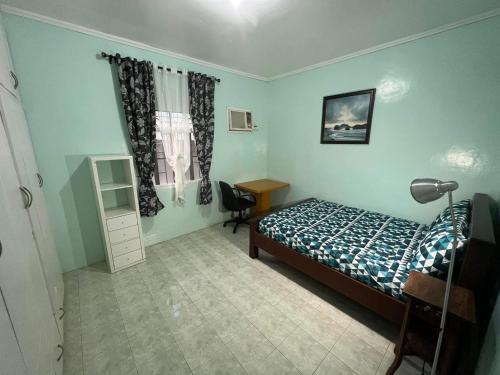a bedroom with a bed and a desk and a window at SSC Transient House & Staycation - Imus in Imus