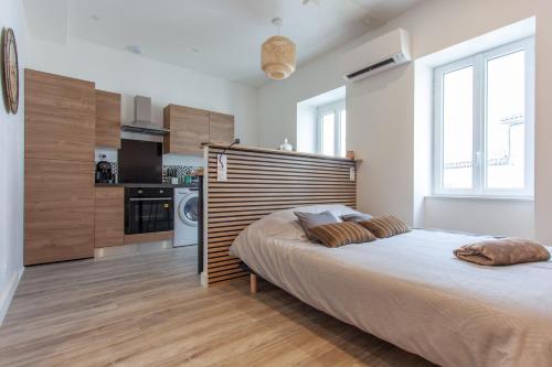 um quarto com uma cama grande e uma cozinha em Le Refuge Valencien - Douceur et Élégance em Valence-sur-Baïse