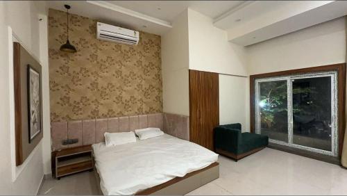 1 dormitorio con cama blanca y ventana en Hotel DC en Bhopal